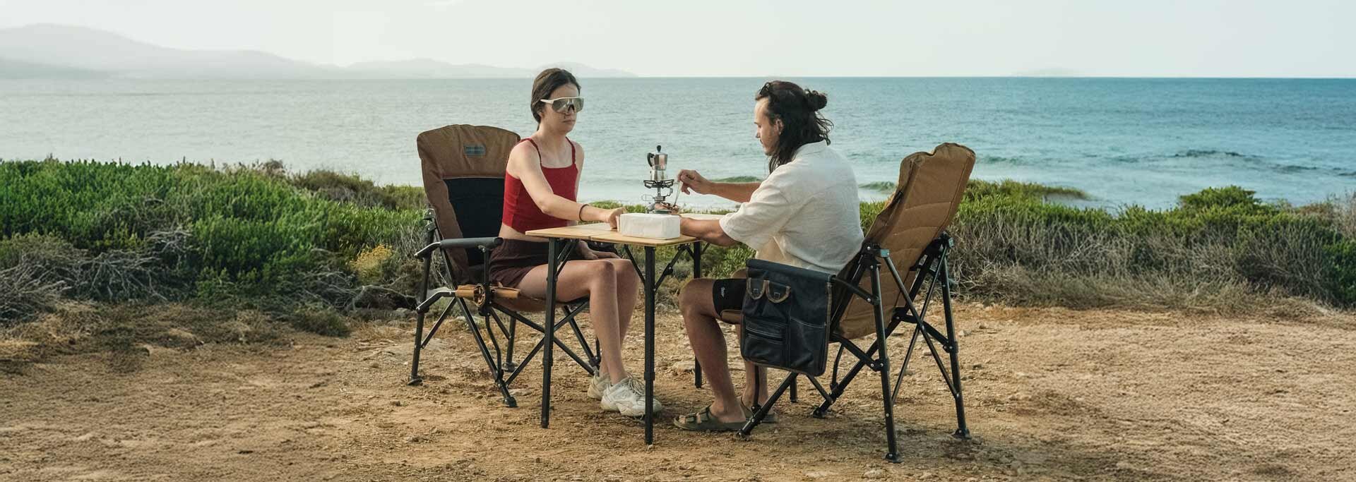 Campingset aus zwei Stühlen und einem Tisch am Meer