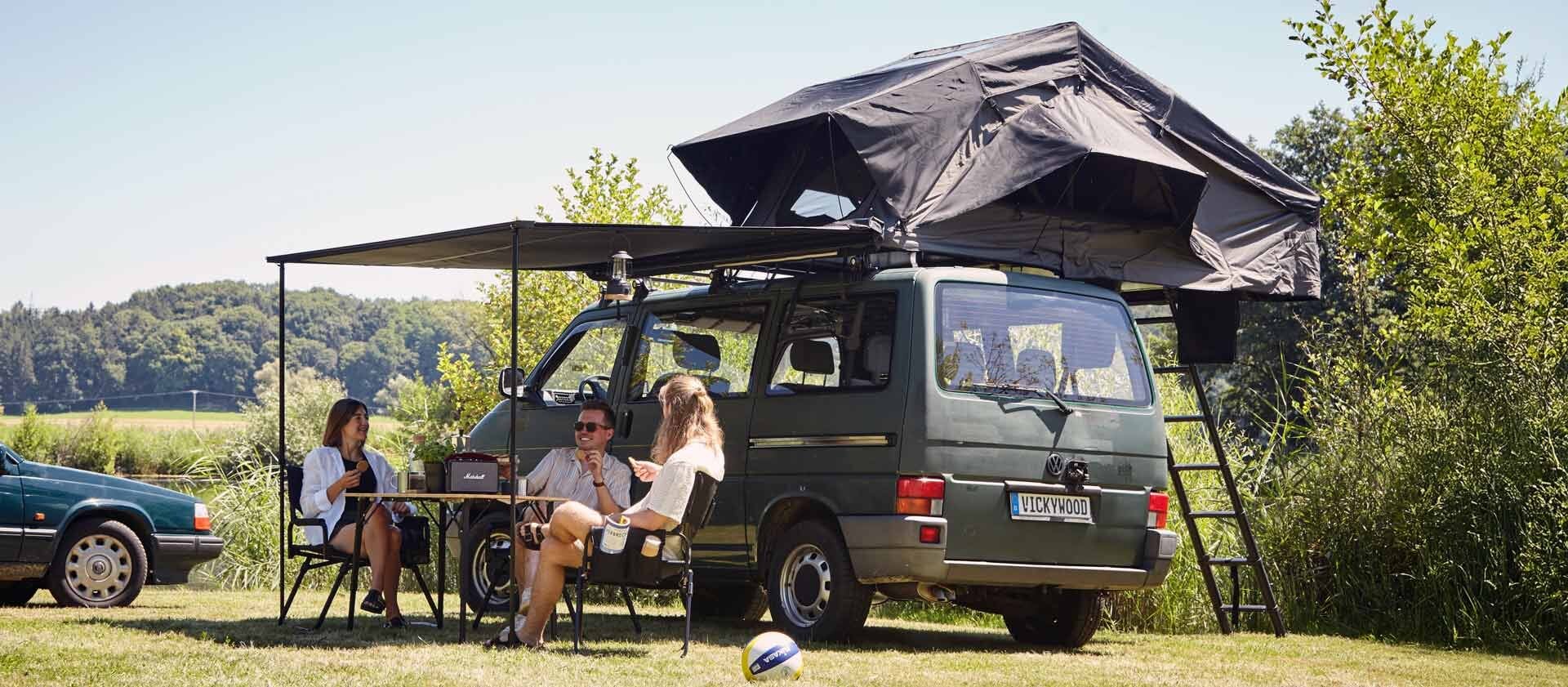 Camping-Setup mit Markise und Dachzelt am VW-Bus