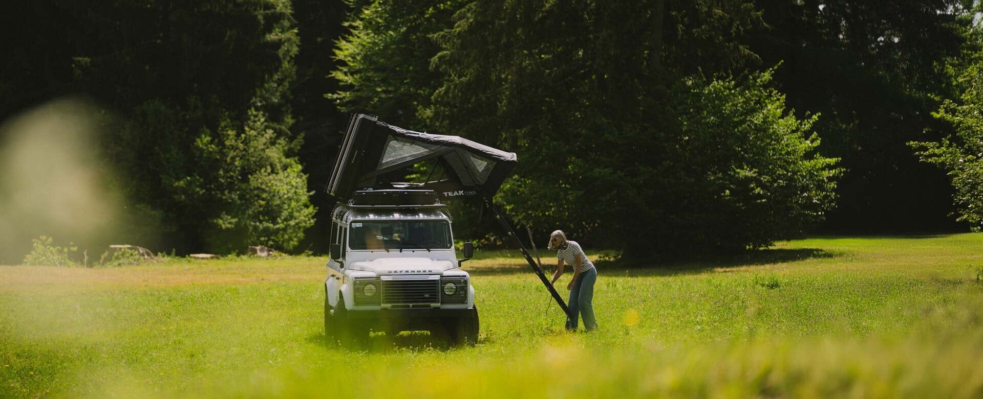 Woman setting up her hybrid rooftop tent.