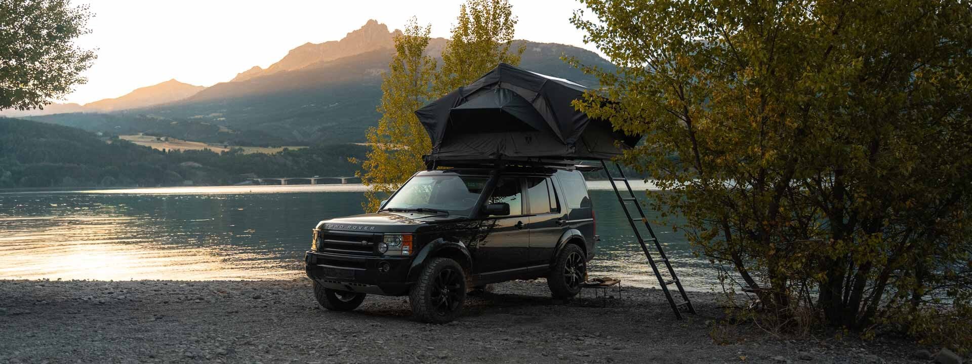 Land Rover mit Dachzelt am See.