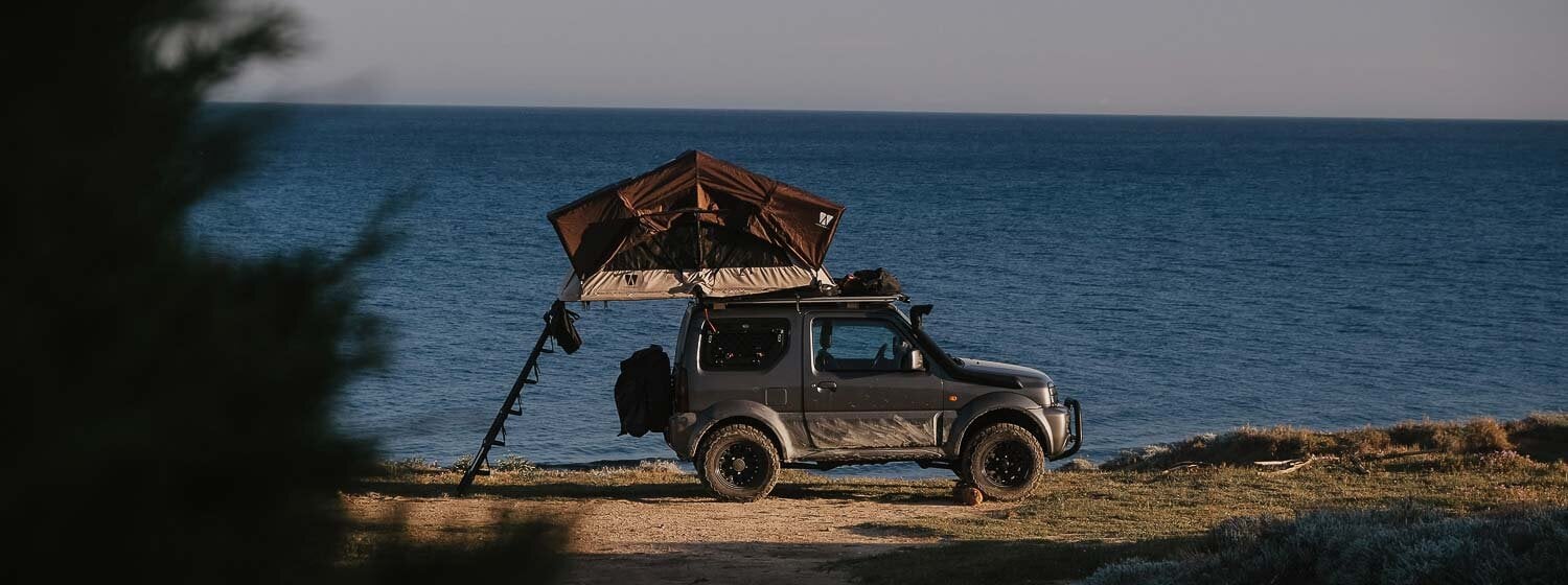 Suzuki Jimny mit VICKYWOOD Dachzelt am Meer.