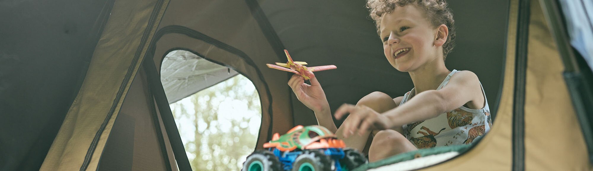 Kid in Rooftop Tent playing.